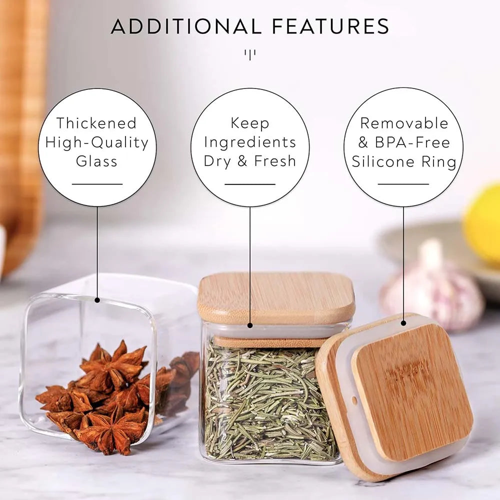 Clear glass spice jars with bamboo lids containing dried herbs and spices