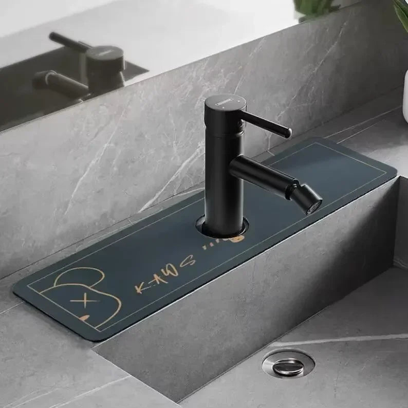 A modern matte black faucet mounted on a dark blue mat in a bathroom sink area.