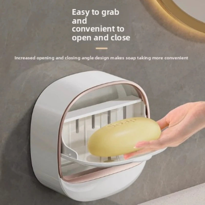 A hand is opening a wall-mounted soap holder with a lid to access the soap.