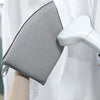 A gray portable ironing board with a handle is shown next to a white garment steamer.