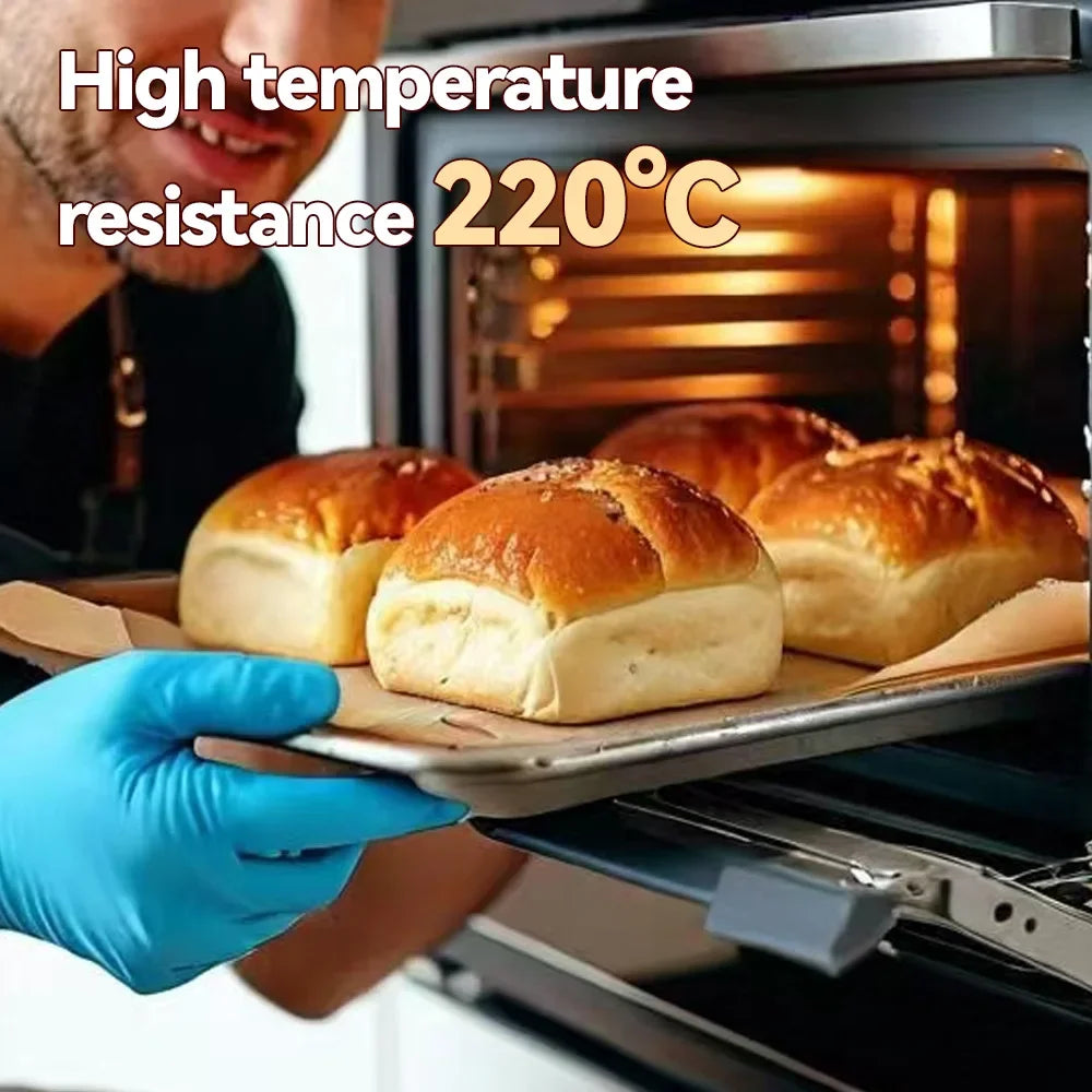 A hand in a blue glove is placing a baked item onto a non-stick baking parchment sheet inside an oven.