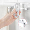 A hand is using a white rotating closet organizer hook to hang a towel on a metal bar.