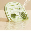 A light green portable foldable foot bath tub is being filled with water from a dispenser.