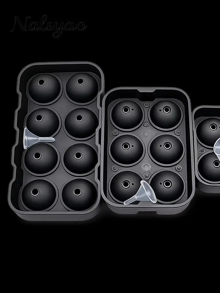 A set of black silicone sphere ice molds for whiskey and cocktails, displayed in a packaging tray.