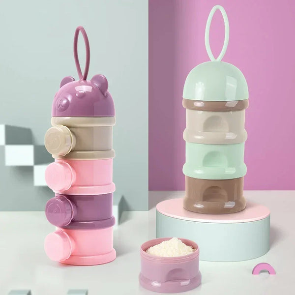 A layered silicone food storage box for baby snacks in shades of purple, pink, and mint green.