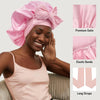 A woman wearing a pink satin sleeping cap with an adjustable bow and long straps