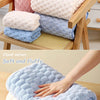 A stack of soft, fluffy bath towels in various pastel colors including pink, lavender, and blue.