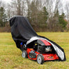 A red lawn mower is covered by a black heavy-duty protective cover outdoors on a grassy field.