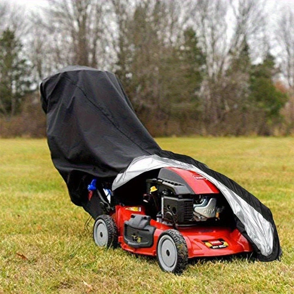 A red lawn mower is covered by a black heavy-duty protective cover outdoors on a grassy field.