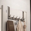 A modern silver over-the-door organizer rack with extended arms mounted on a light gray door.