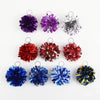 Eine Sammlung farbenfroher Pom-Pom-Anhänger in lila, silber, rot, blau und gelb.