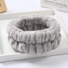 A thick, gray microfiber wrist sweatband set for face washing and skincare is displayed in a white box.
