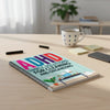 A notebook titled ADHD Simple Solutions for Cleaning and Organizing lies on a wooden table next to a mug and some small block
