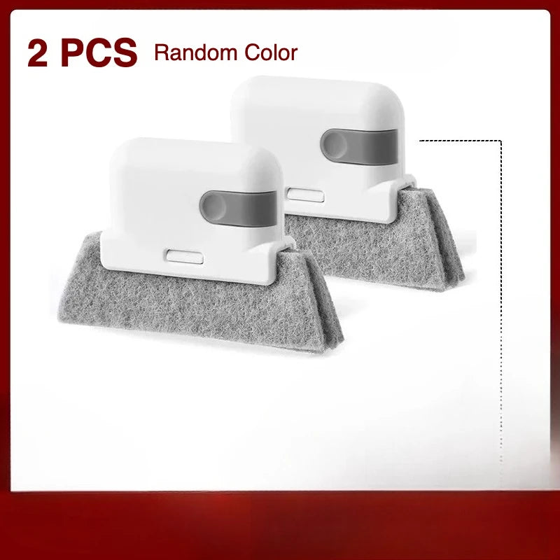 Two white cleaning brushes with gray accents resting on a gray cloth.