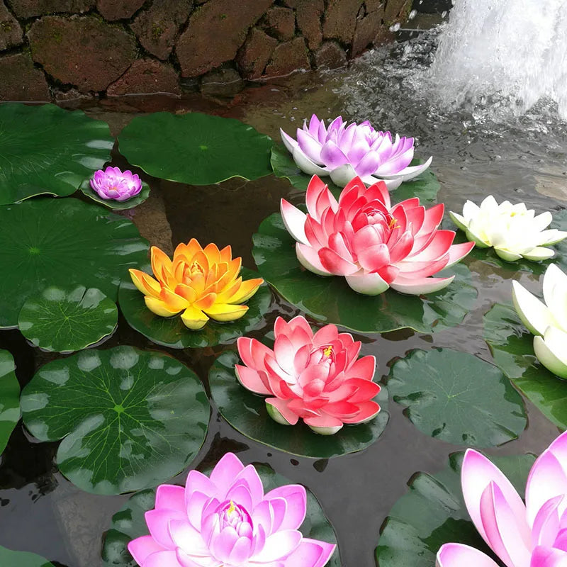 Pink and yellow artificial lotus flowers floating on water with a waterfall background