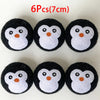 Six black and white wool dryer balls shaped like owls, each approximately 7 cm in diameter.