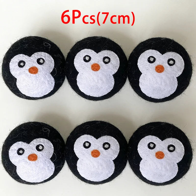 Six black and white wool dryer balls shaped like owls, each approximately 7 cm in diameter.