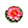 A vibrant artificial lotus flower with pink and red petals and a yellow center, set against green leaves.