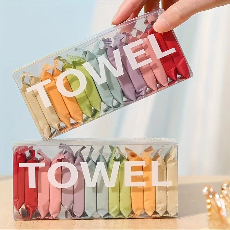 A hand holds a clear plastic container filled with colorful disposable facial washcloths or towels.