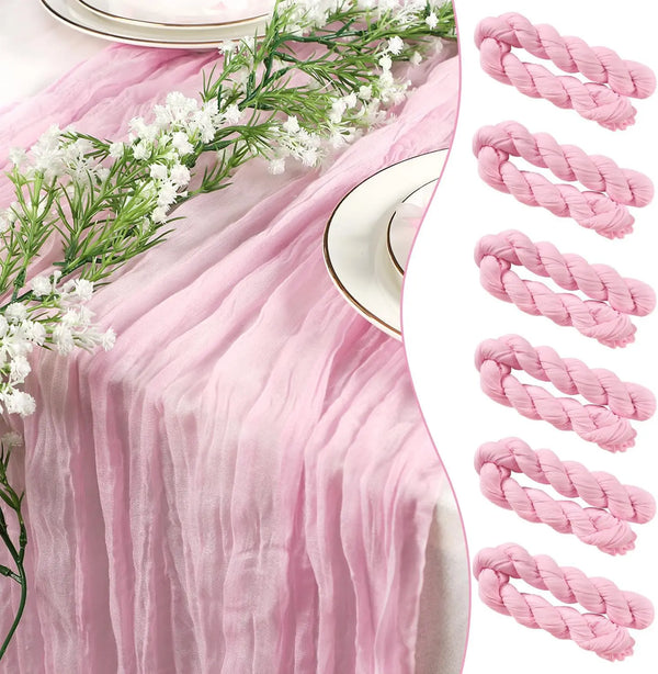Pink sheer fabric table runner set with white floral greenery and pink twisted ribbon accents