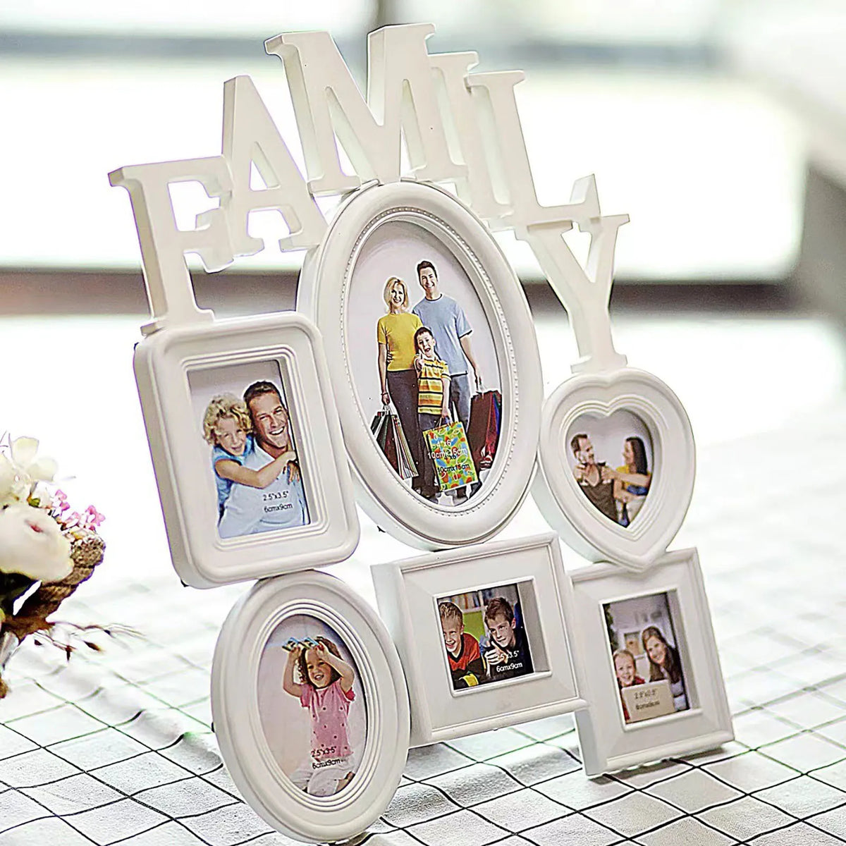 Décor mural de famille en bois blanc avec diverses photos et lettres formant le mot FAMILLE