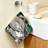A green and black Totoro cartoon-themed hanging hand wiping towel is displayed on a wall.