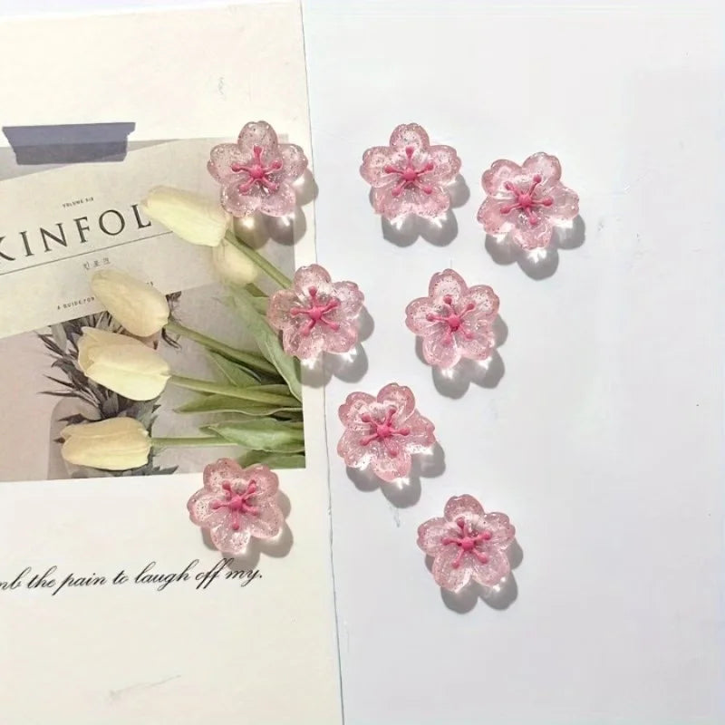 Un juego de imanes de flor de cerezo rosa con delicados diseños florales sobre fondo blanco.