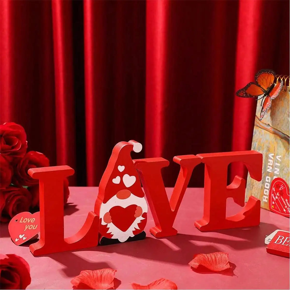 رسومات حروف كلمة LOVE الخشبية الحمراء وزينة قلب على شكل بيضة على طاولة.