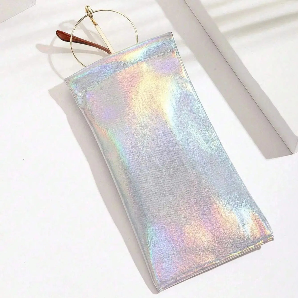 A translucent iridescent PU leather squeeze eyeglass case with a gold-colored loop and wooden accent.