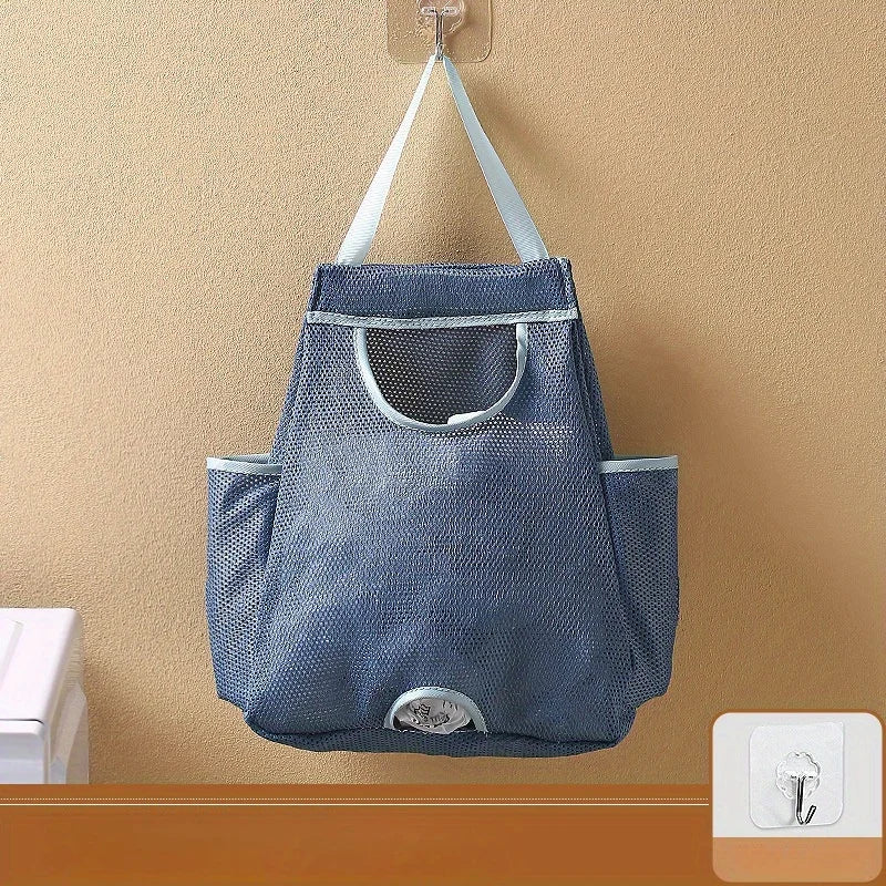 A gray mesh garbage bag storage organizer hanging on a wall hook.