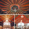 An overhead view of a richly draped ceiling using sheer chiffon fabric in shades of orange, green, and gold for an event.