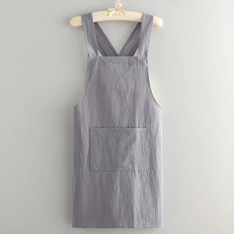 A gray linen cotton kitchen apron hanging on a wooden hanger.