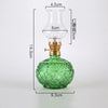Vintage rustic green glass oil lamp with a clear glass chimney and brass fittings