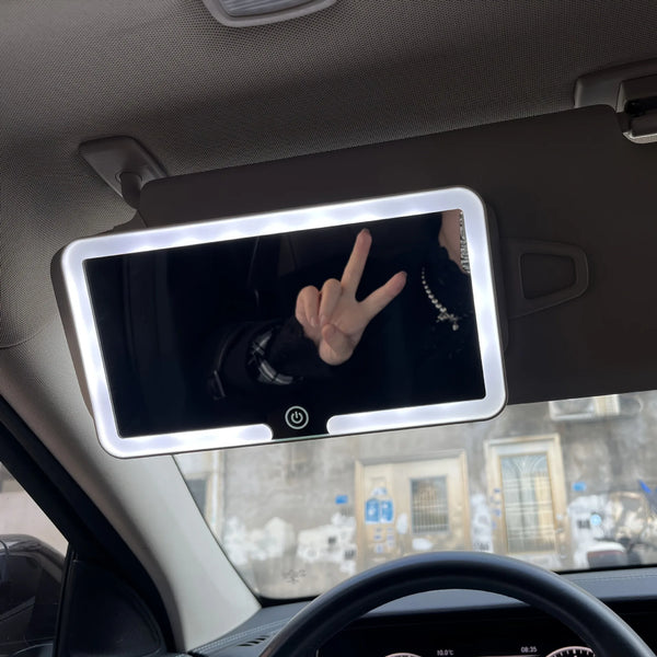 A vanity makeup mirror with an LED light is mounted on a car's sun visor.