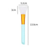 A white silicone facial mask brush with an orange handle and a light blue base, shown next to dimension lines.