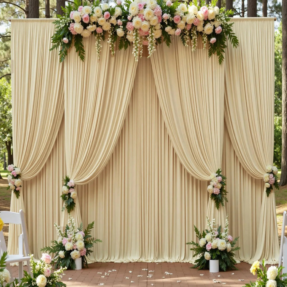 Fondo de tela beige con cortinas fruncidas y follaje floral usado como decoración para bodas o eventos.