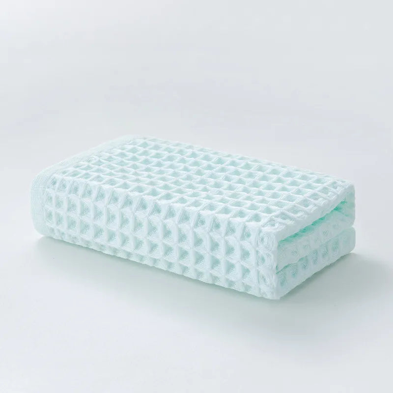 Eine Stapel von mintgrünen Luxus-Baumwoll-Waffelturischen.