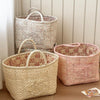 A collection of vintage floral storage baskets in cream and pink tones, featuring textured fabric and handles.
