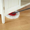 A red triangular microfiber mop head replacement pad is resting on a wooden floor beneath a white cabinet.
