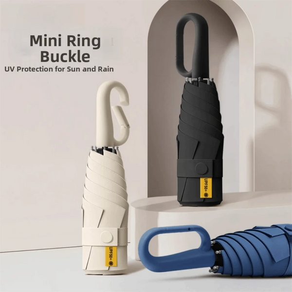 A white mini ring buckle and a black folding umbrella are displayed against a light background.