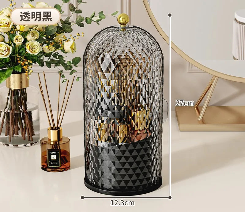 A black glass organizer for makeup brushes with a gold lid and decorative geometric pattern.