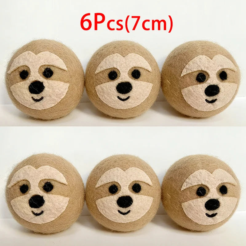 Six round felt dryer balls shaped like dog faces, made of natural wool.