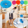 A woman is using an extendable microfiber duster on a wooden floor, demonstrating the cleaning tool.