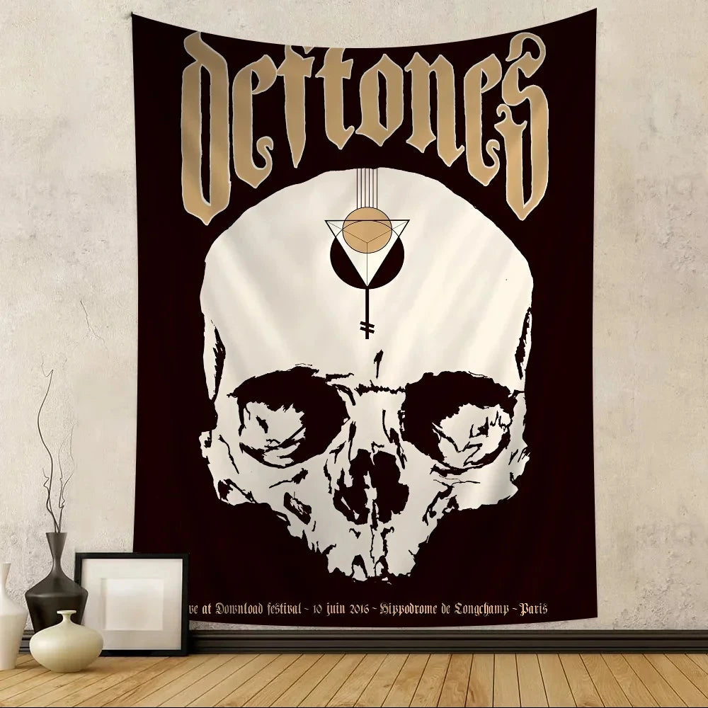 A dark tapestry featuring a stylized skull design with the word Deftones in gold lettering.