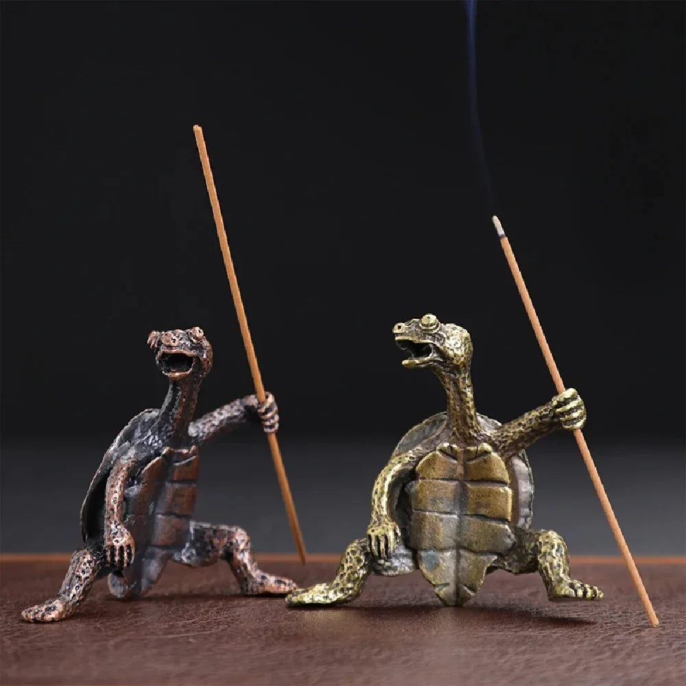 Une petite figurine de tortue en métal avec de la fumée s'en échappant, sur un fond sombre.