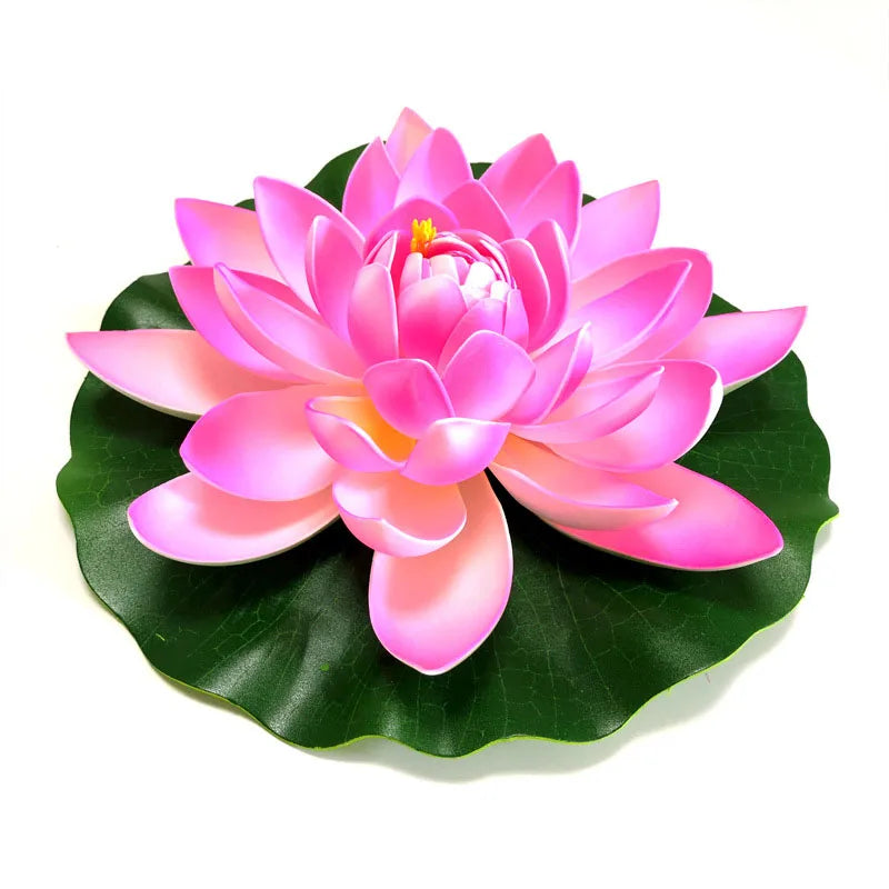 A vibrant pink artificial lotus flower blooming on a green leaf.