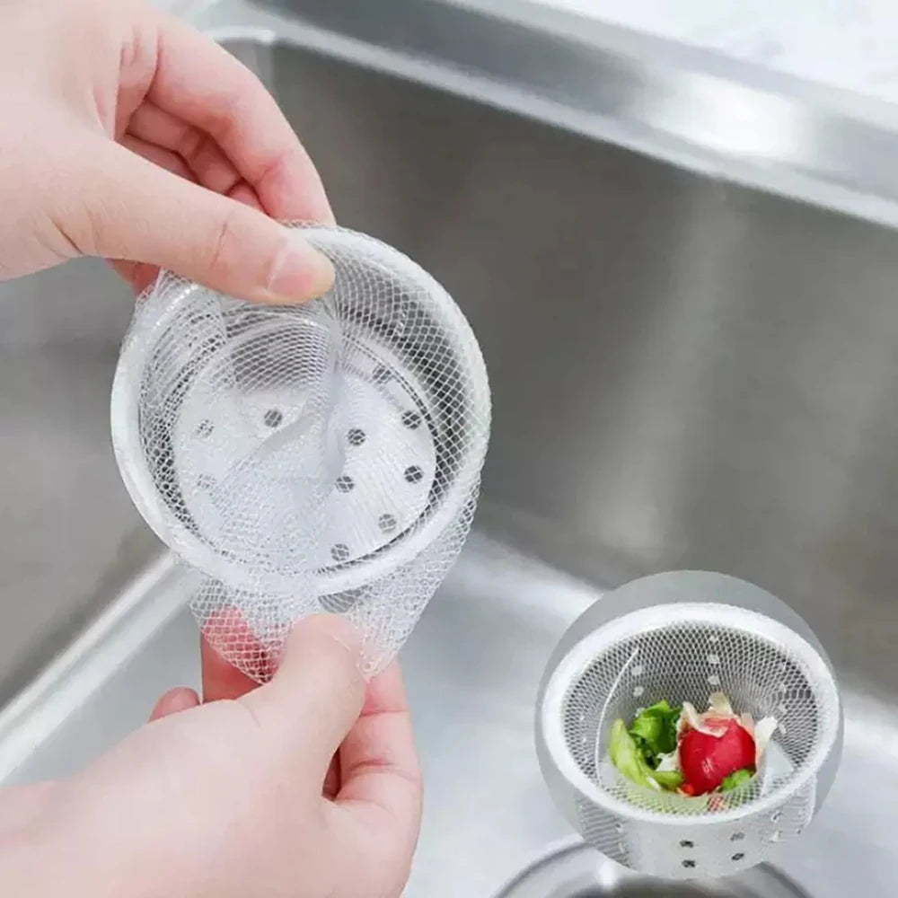 A hand is holding a reusable mesh strainer bag over a kitchen sink drain.