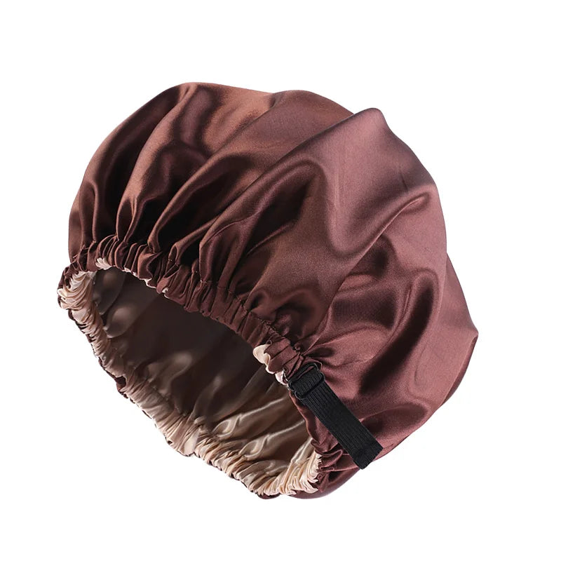 A close-up of a mauve satin sleep cap with a gathered edge, designed for curly and natural hair.