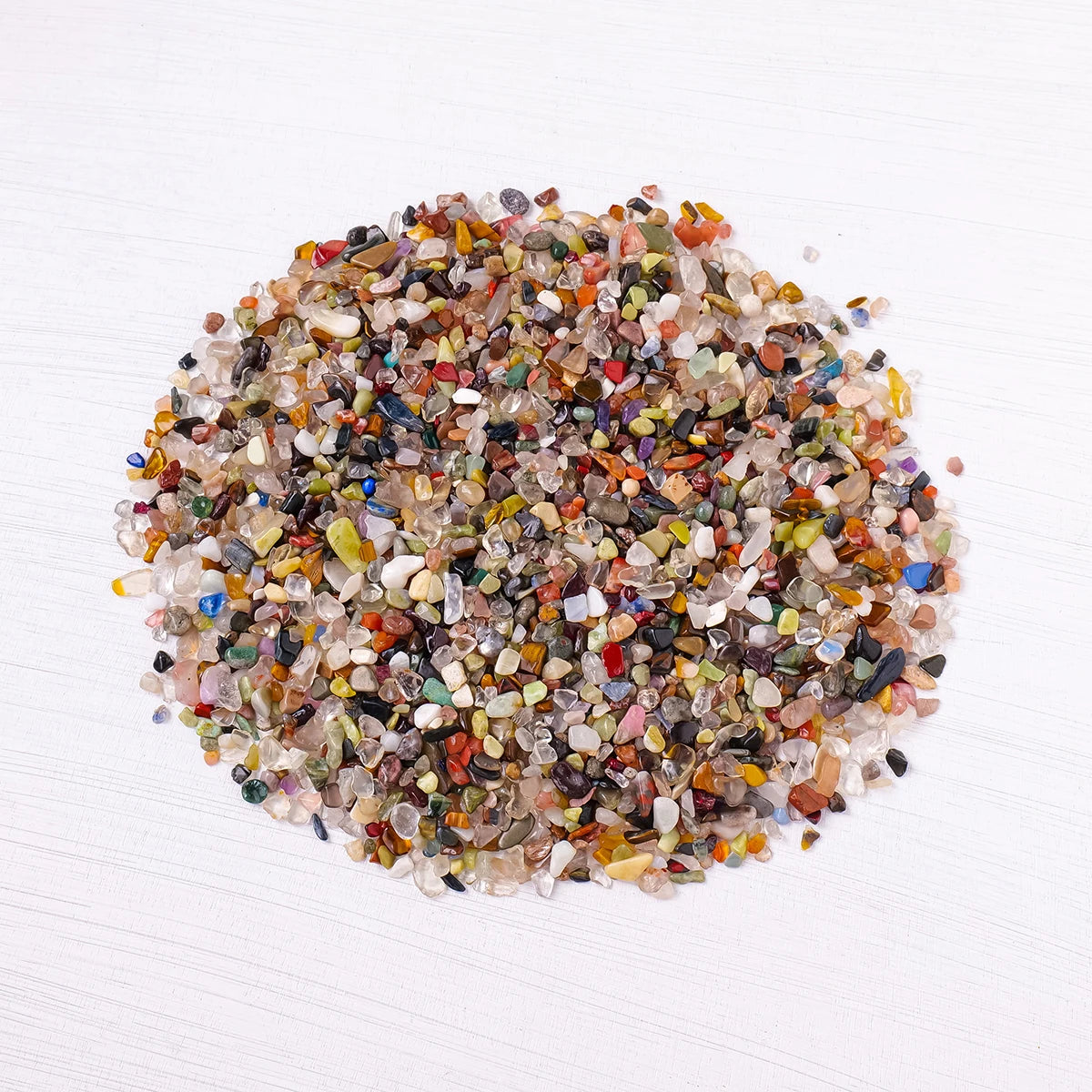 Un tas de gravier de cristal naturel avec diverses couleurs : ambre, orange, violet et transparent.