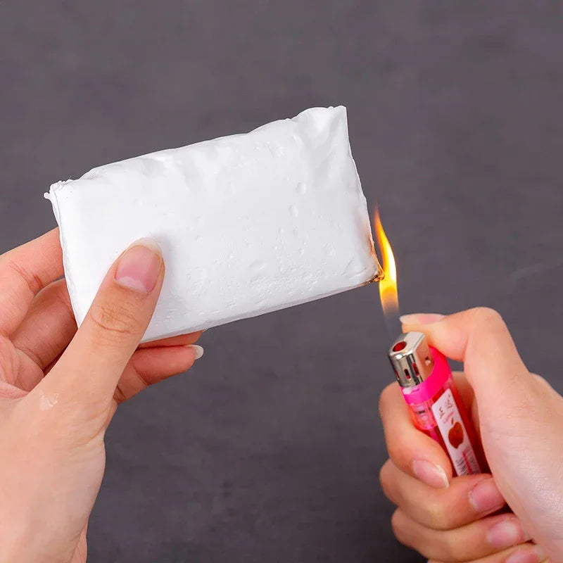 A hand holds a white clay product being heated by a flame, demonstrating the Universal Pipe and Wall Hole Sealant Clay.